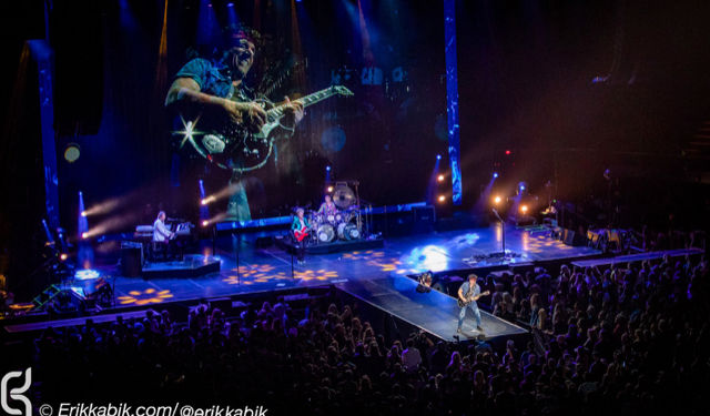 Neal schon wide shot plays guitaron stage smooth purple backdrop